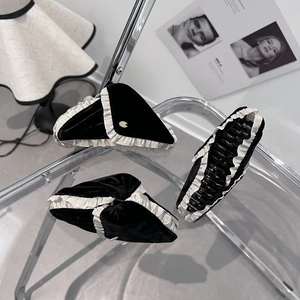 Elegant black velvet claw clip with white ruffled lace trim and gold charm detail