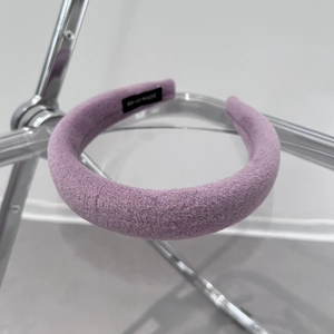 Detail of purple velvet plush headband with thick sponge padding on a clear chair