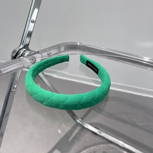 Detailed view of handmade green quilted fabric headband with a black hand made label