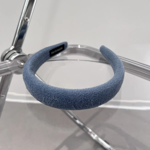 Detailed view of handmade blue wool velvet padded headband with interior woven label