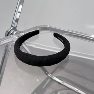 Detail of black padded headband with diamond quilted fabric and Hand Made label