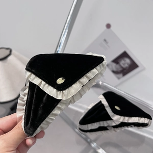 Elegant velvet triangle shark clip with white ruffle trim and gold logo detail