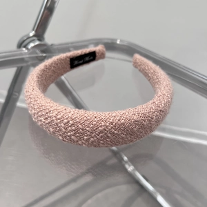 Macro shot of pink tweed headband with hand made label showing texture detail