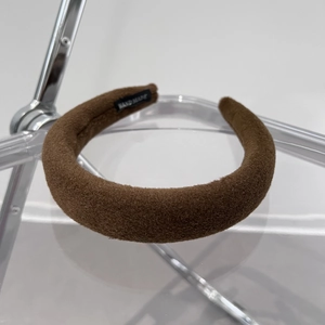 Close-up of thick coffee brown velvet headband with handmade woven label detail