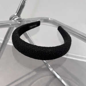 Detail of black tweed sponge headband with a handmade label on the inner side