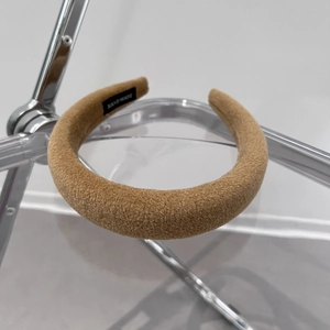 Macro shot of thick camel wool headband showing soft texture and handmade label
