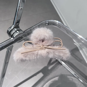 Dettaglio molletta per capelli in peluche rosa con elegante fiocco in pelle