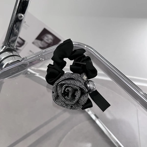 Detailed shot of fabric rose hair scrunchie with plaid patterns and sparkling rhinestones