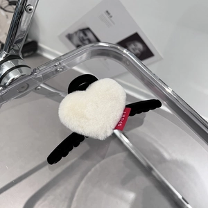 Vue détaillée de la pince à cheveux cœur en peluche avec ailes d'ange et étiquette sport