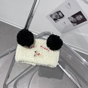 Detailed embroidery of a cute bear with black pom-poms on a white coral fleece headband