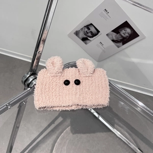 Detailed close-up of a pink plush headband with cute bear ears and bead eyes for washing