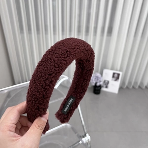 Detail view of burgundy plush headband with soft lamb wool texture and handmade label