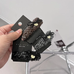 Handheld group of three autumn winter tweed hair claws with black bows and golden charms