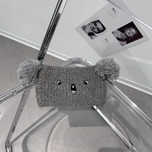Detail showing plush grey koala headband texture and embroidery on clear chair