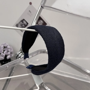 Détail du serre-tête large en tricot bleu foncé montrant la texture du tissu fin
