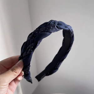 Detail of navy blue braided headband with white polka dots and anti-slip lining