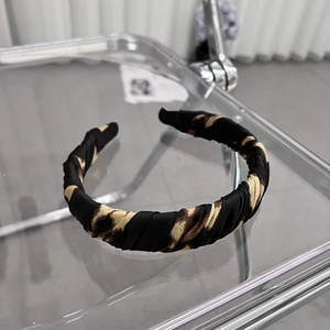 Close-up of leopard print headband featuring stylish pleated fabric and satin texture