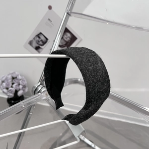 Détail d'un serre-tête en laine gris foncé avec doublure noire sur un support