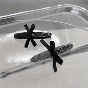 Détail de barrettes à cheveux en laine avec nœud en cuir et cristaux scintillants