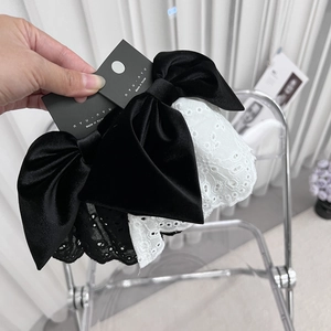 Dettaglio di fermagli per capelli in velluto nero e pizzo bianco con ricami pregiati