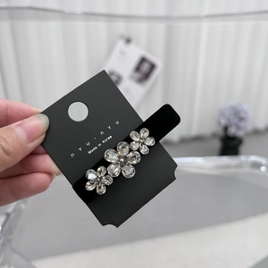 Detail van de fluwelen haarclip met drie fonkelende kristallen bloemen op displaykaart