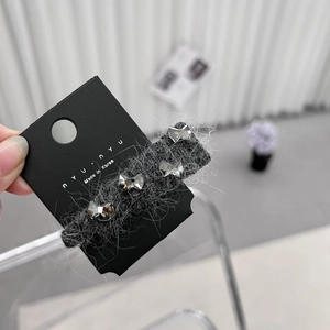 Vue détaillée de quatre boucles d'oreilles papillon en cristal sur support en peluche