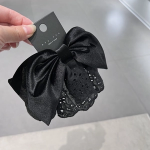 Dettaglio del fermaglio per capelli a fiocco in velluto nero con pizzo e clip coreana