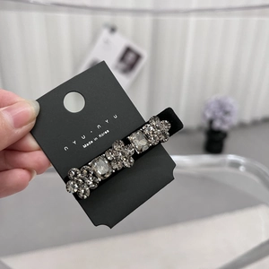 Detailopname van de fluwelen haarklem met sprankelende strass-steentjes op de displaykaart