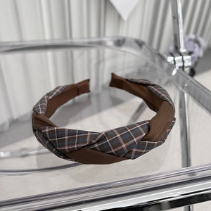 Detail of cross-knot fabric headband with classic brown plaid and solid textures