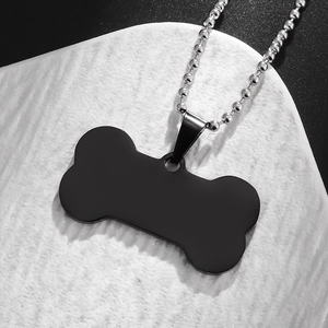 Macro shot of matte black bone-shaped pendant with silver bead chain for pets