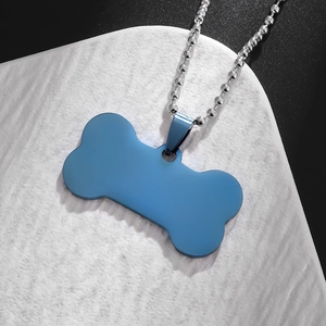 Detailed close-up of blue bone-shaped metal pendant with a silver ball chain necklace