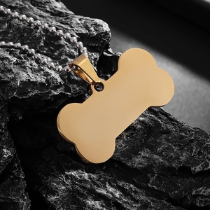 Mirror polished gold bone pendant with bead chain on a natural black stone background