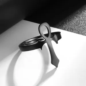 Bague égyptienne Ankh en acier inoxydable noir poli sur un socle blanc minimaliste