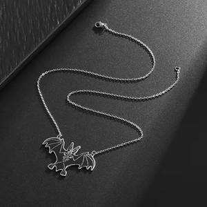 Gothic stainless steel necklace with bat pendant featuring skeleton detail on dark background