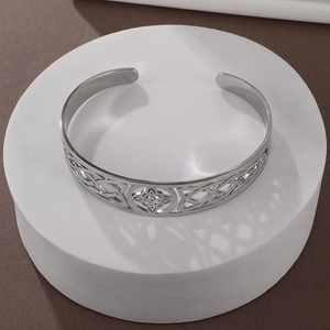 Detailed macro of silver hollow-out celtic knot bangle with stainless steel texture