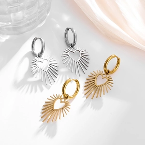 Detail von Herz-Creolen mit Sonnenstrahl-Effekt in Gold und Silber auf Seidenstoff