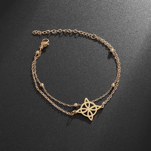 Nahaufnahme eines goldenen Doppelarmbands mit Hexenknoten-Anhänger und Perlen