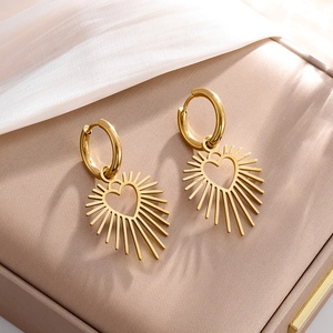 Goldene Edelstahl-Ohrringe mit Herzanhängern im Sonnenstrahl-Design auf Schmuckbox