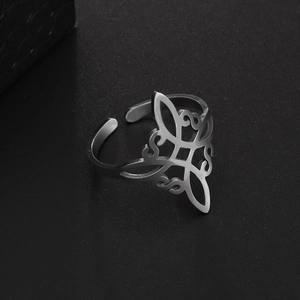 Detailed close-up of silver Irish knot stainless steel open ring on a black textured surface