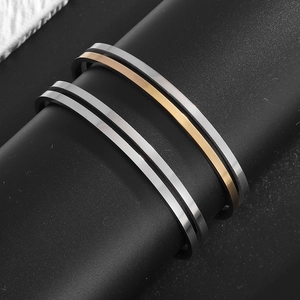 Makroaufnahme von polierten silbernen und roségoldenen Edelstahl-Armreifen im Doppel-Design