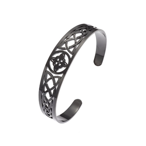 Detailed macro view of black stainless steel C-shape open bracelet with Celtic knot patterns