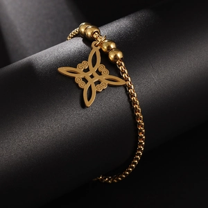 Detailaufnahme eines vergoldeten Edelstahl-Armbands mit Keltenknoten auf schwarzem Sockel
