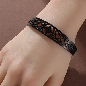 Matte black stainless steel hollow Celtic knot open cuff bracelet on model's wrist