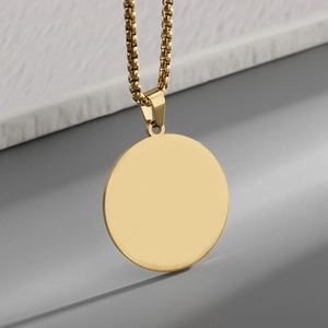 Detail of a minimalist polished gold round pendant with a high-quality box chain necklace
