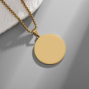 Close-up of minimalist gold-plated stainless steel round pendant on a box chain