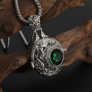 Macro detail of silver vintage locket pendant with faceted emerald green gemstone inlay