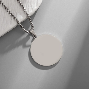 Detailed view of circular stainless steel pendant on a box chain for custom engraving