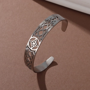Macro detail of silver stainless steel cuff bracelet with Celtic witch knot pattern