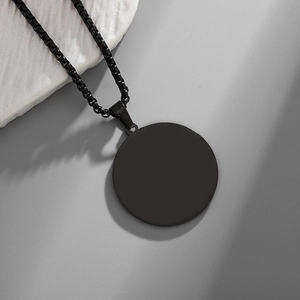 Detail view of a matte black round pendant necklace with a durable box chain