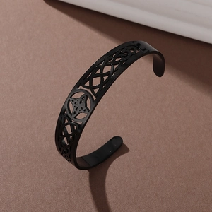 Detail of black stainless steel open cuff bracelet featuring an intricate Celtic knot design